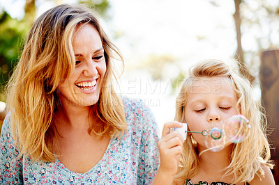 Buy stock photo Blowing bubbles, mother and girl in park for bonding, together and outdoor for fun. Soap toy, child and woman in garden with summer, holiday and daughter with care and play in nature for weekend