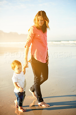 Buy stock photo Holding hands, sunshine and mom with child at beach for bonding, summer vacation and holiday together. Family, flare and mother with kid in waves, ocean and seaside for fun, trip and weekend outdoor