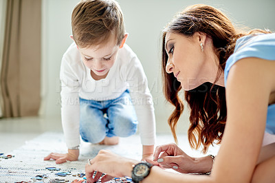 Buy stock photo Mom, child and puzzle for help with education toys, development and bonding in home. Woman, son and learning with growth, support and love or logic activity for academic games on bedroom floor