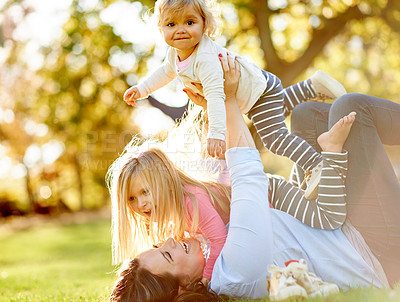 Buy stock photo Lifting, children and woman in nature, fun or playing on summer holiday, bonding and laugh on break. Bokeh, flare and mom with kids on weekend, happy and love for daughters, outdoor and together