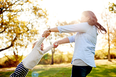 Buy stock photo Mom, spin child and fun at park with smile, bonding and flare with love, play and summer in nature. People, mother and daughter with games for toddler, swing or holding hands with flare in Argentina