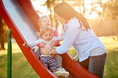 Buy stock photo Outdoor, slide and mom with children, playground or bonding with daughters on weekend, happy or love. Park, woman and smile with toddler in nature, growth and development of girls, family and care