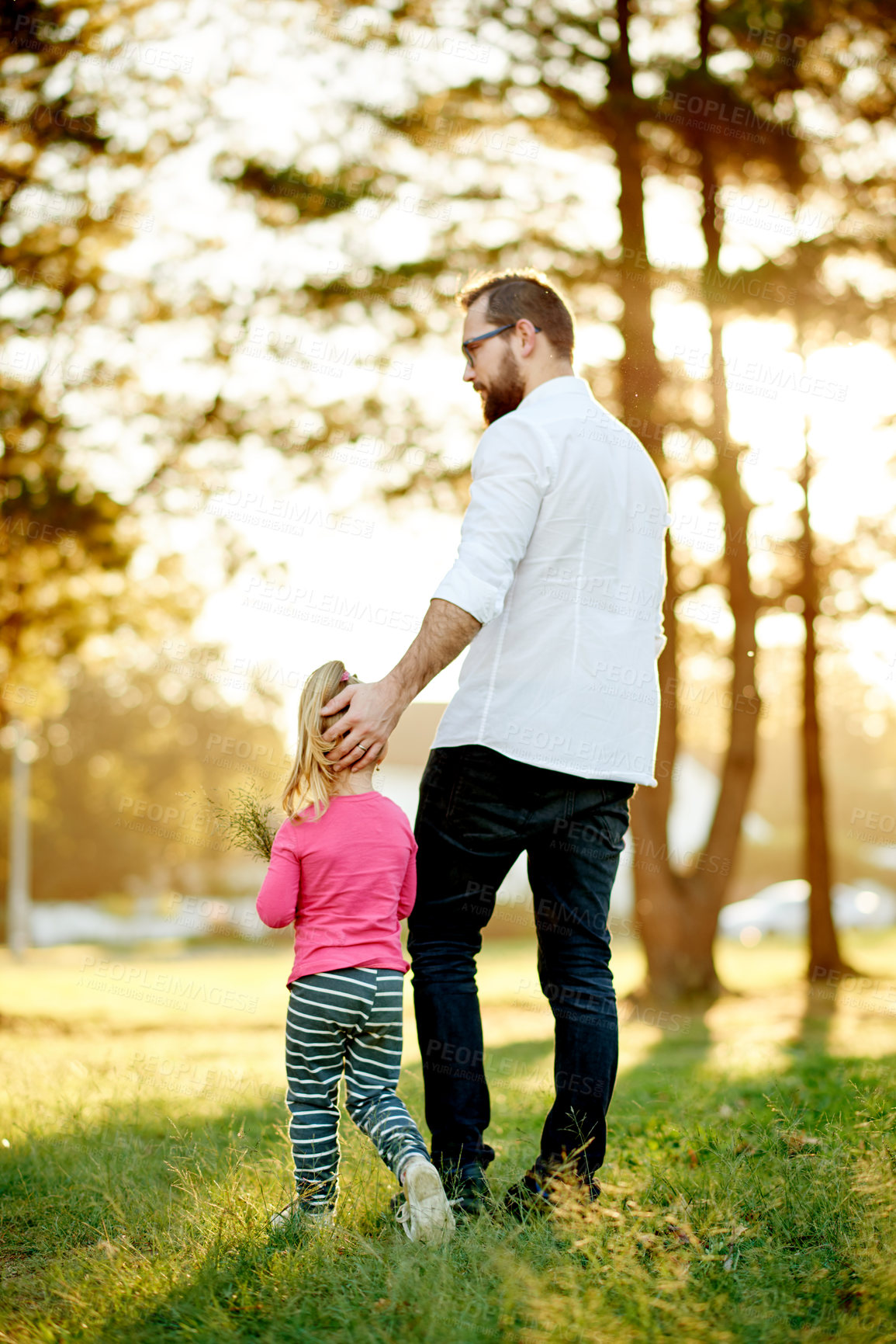 Buy stock photo Dad, girl and walk at park in spring, nature or bonding with helping hand for picking flowers. People, father and daughter with back, learning and choice for plants, discussion and garden in Spain