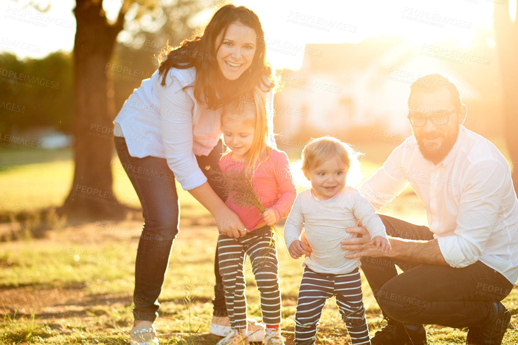 Buy stock photo Parents, children and smile in portrait at park with bonding, care and excited with flare in nature. Happy family, people and kids in garden, summer or outdoor with love for relationship in Spain