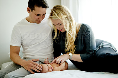 Buy stock photo Happy, relax and parents with baby in home with calm, care and love in family time. Bonding, smile and newborn with mother and father for support, comfort or trust together in bedroom at house.