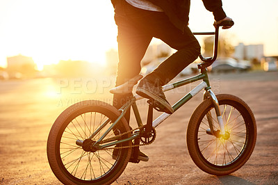 Buy stock photo Legs, person and riding bicycle in city for travel, endurance training and cardio exercise. Cyclist, sunset and bike for fitness skills, sports workout and sustainable transport of stunt practice