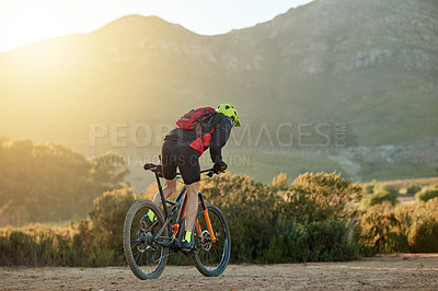 Buy stock photo Man, cyclist and back with mountain bike for extreme cycling, off road or dirt track in nature. Active, male person or biker riding with helmet or sunset on desert terrain in outdoor wilderness