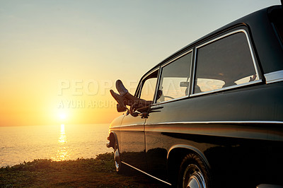 Buy stock photo Shot of a young woman with her legs hanging out of the car's window on a roadtrip