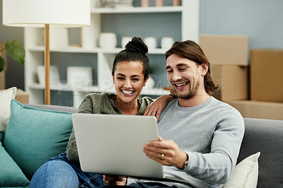 Buy stock photo Happy couple, relax and online shopping with laptop on sofa in new home for furniture or decor. Man, woman or homeowners with boxes or smile on computer for browsing ecommerce or house improvement