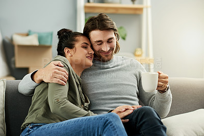 Buy stock photo Coffee, hug and relax with coupe on sofa in living room of new home together for investment. Boxes, drink and moving day with people embracing in apartment for finance, growth or property mortgage