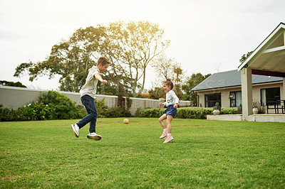 Buy stock photo Children, ball and playing in backyard by home for bonding together, motor skills and cognitive development. Siblings, brother or teaching girl football in garden for fun activity or learning support