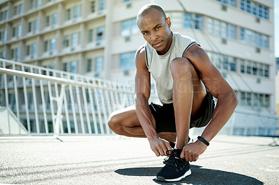 Buy stock photo Man, tie laces or portrait in city for run, ready or start training with cardio, health and fitness in street. Runner, athlete or black person prepare for exercise with sneakers for challenge in town