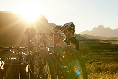 Buy stock photo Shot of a man and woman riding their bicycles in the countryside