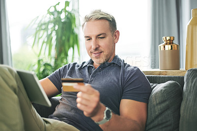 Buy stock photo Credit card, tablet and man with online shopping on couch for ecommerce, payment or sale. Customer, website and person with banking app in living room on sofa for transaction, subscription or order