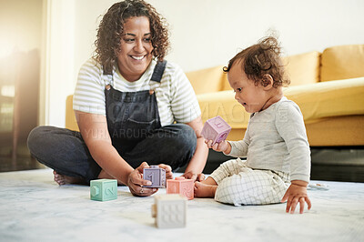 Buy stock photo Mother, baby and building blocks on a living room floor for education, bonding and playing in their home. Learning, toys and child development with mother and toddler having fun with educational game
