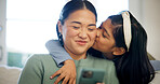 Phone, mom and child on sofa with kiss, hug and love connection for social media browsing. Asian family, happy mother and kid in home with affection, healthy relationship or online reels with embrace