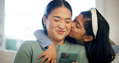 Buy stock photo Phone, mom and child on sofa with kiss, hug and love connection for social media browsing. Asian family, happy mother and kid in home with affection, healthy relationship or online reels with embrace