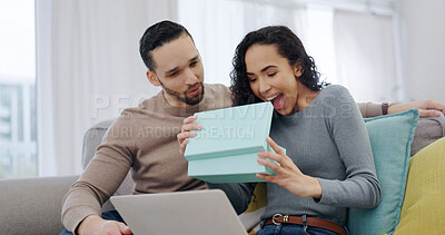 Buy stock photo Couple, home and wow with present for love on anniversary celebration, smile or partner appreciation. Surprise, gift box and happy people on sofa with shock, connection and gratitude with laptop