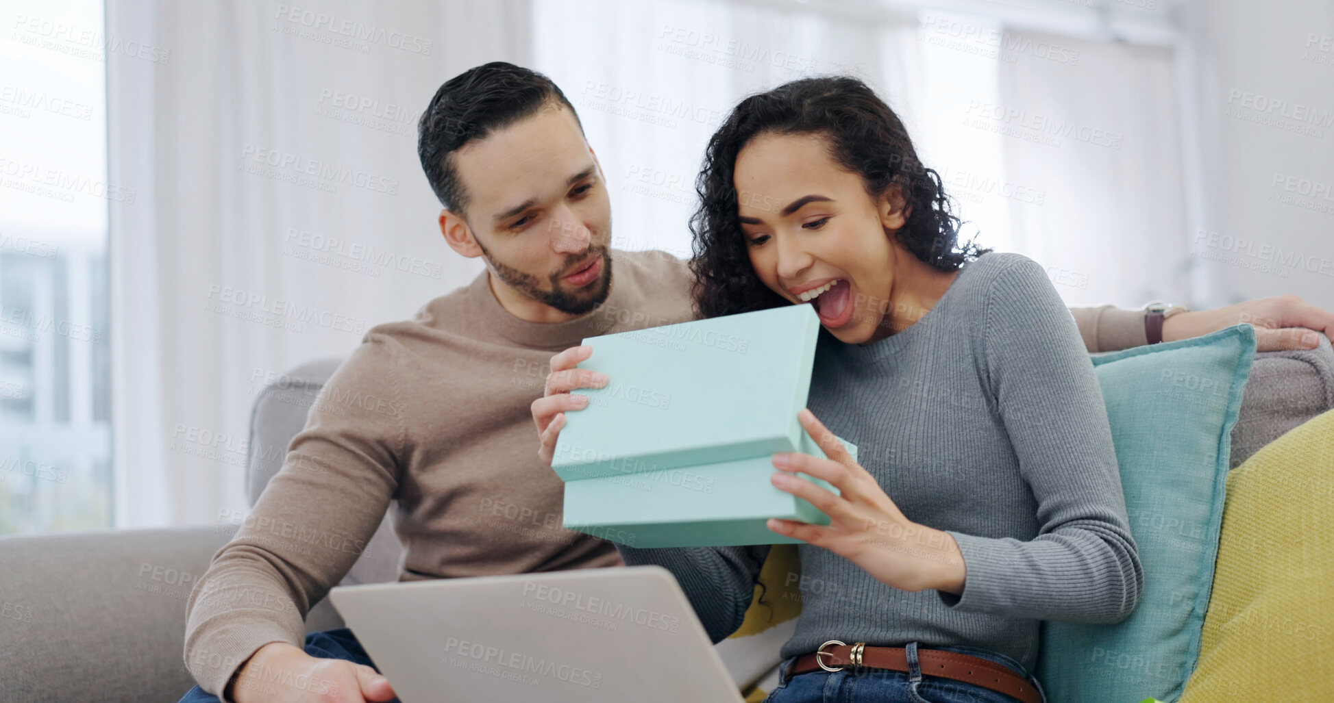 Buy stock photo Couple, home and wow with present for love on anniversary celebration, smile or partner appreciation. Surprise, gift box and happy people on sofa with shock, connection and gratitude with laptop
