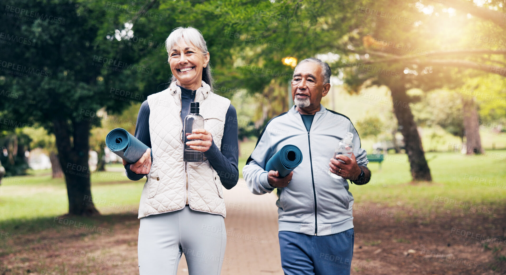 Buy stock photo Smile, old couple and walk at park for yoga, cardio exercise and training for healthy lifestyle. Interracial, senior people and jogging in nature with bottle, pilates fitness and workout for wellness