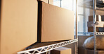 Warehouse, empty and box on shelf in workshop for shipping, supply chain and inventory. Cardboard, background and rack with package, parcel and delivery stock for distribution, shipment and logistics