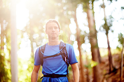 Buy stock photo Backpacking, portrait and man in forest, outdoor and adventure for traveller in nature or serious. Travel, hiker and person on journey in woods, trekking and tourism of environment, morning or Canada