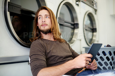 Buy stock photo Thinking, laundromat and man with tablet, washing clothes and social media with daydreaming. Person, internet and customer with weekly chore, technology and decision with connection and choice