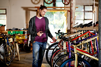 Buy stock photo Tablet, choice or man in bicycle shop to check inventory, wheel or research in small business. Frame options, mechanic and owner in store for maintenance update, inspection or bike sales in garage