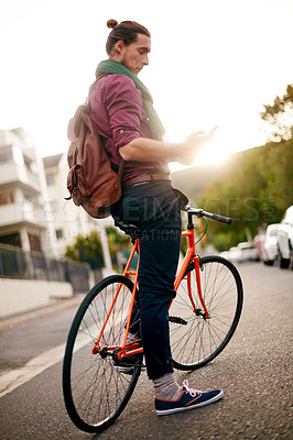 Buy stock photo Location, phone or man on bike in street for eco friendly transport, commute or city travel. Search, texting or male designer in urban town with address, mobile app or bicycle for online directions