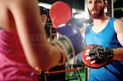 Buy stock photo Boxer, teaching or woman with trainer for fighting exercise, boxing punch or self defense skills. Pads, learn or client in sports practice for training technique or fitness workout with coach in gym