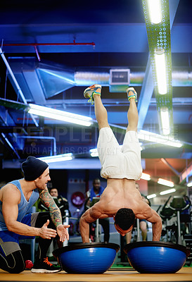 Buy stock photo Fitness, man or handstand on bosu ball at gym with instructor guidance, core strength or balance. Low angle, personal trainer or athlete with workout for muscle development, technique help or support