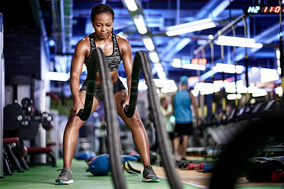 Buy stock photo Battle ropes, training and black woman in gym for exercise, bodybuilder workout and fitness. Sports, intense and person with muscle strength, power and equipment for wellness, health and challenge