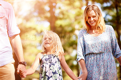 Buy stock photo Parents, child walking and holding hands for family vacation, holiday and bonding together in park. Mother, father and happy kid in nature for connection, support and travel with girl on journey