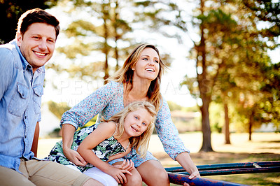 Buy stock photo Playground, parents and girl on roundabout for family weekend fun, happy bonding or love. Smile, caring man and woman with child on playing equipment together, park visit or support in summer