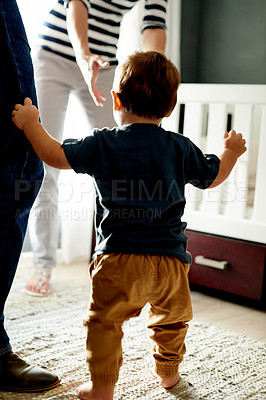 Buy stock photo Toddler, child and walking with parents in home for motor skill development, growth or learning. Mother, father and teaching kid with first steps, balance or back to encourage with family in nursery