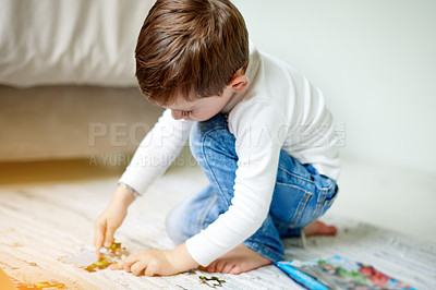 Buy stock photo Child, boy and playing with puzzle at house for learning, problem solving skills and connect pieces. Kid, jigsaw and building games for education, creative activity and toys for cognitive development