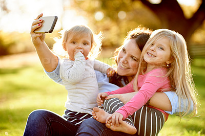 Buy stock photo Mom, selfie and girl children at park with smile, hug and care for post on web, portrait and bonding. People, mother and daughter kids with photography, profile picture and happy on ground in Spain
