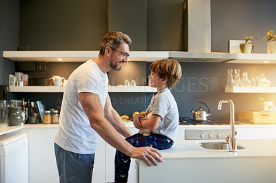 Buy stock photo Conversation, love and father with son in kitchen of home together for morning routine. Bonding, security or smile with boy child and single parent man speaking in apartment for development or growth