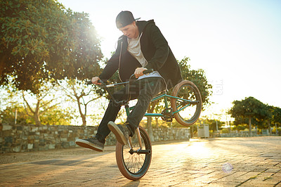 Buy stock photo Urban, tricks and man on bicycle for cycling, training skill or sports in city to practice. Cool person, athlete or stunt biker in town at sunrise for endo, stoppie or outdoor activity for biking