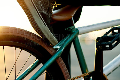 Buy stock photo Closeup, wheel and person on bike for trick in city, shoe for stunt or skill outdoor with extreme sport. Cyclist, rider and foot with bicycle frame for challenge or sustainable fitness at sunset