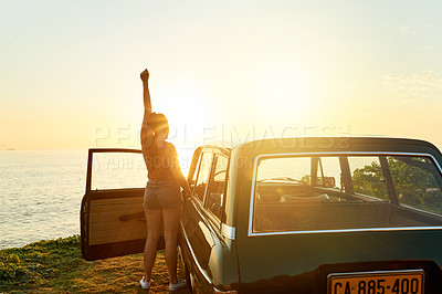 Buy stock photo Shot of a happy young woman enjoying a road trip