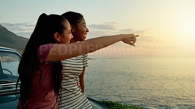 Buy stock photo Road trip, car and lesbian couple with view of beach with pointing, ocean scenery or journey pause. Sunset, hug and lgbt women at vehicle for travel adventure, sightseeing nature and bonding together