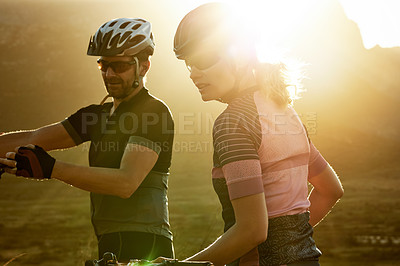 Buy stock photo Sunrise, cycling and man with woman on bicycle for sports hobby, outdoor exercise and workout together. Morning, lens flare and couple on bike talking for adventure, wellness and fitness in nature