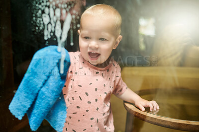 Buy stock photo Child, washing and cleaning window in home for hygiene, health or wellness. Chores, kid and happy baby clean glass with cloth and soap for learning and helping to remove bacteria to sanitize house.
