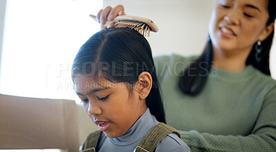 Buy stock photo Kid, happy mother and brush for hair care in home, grooming and help daughter in morning routine. Parent, girl and hairstyle assistance with Asian family, beauty support or bonding together with love