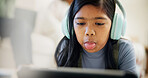 Playful, child and headphones at house with tablet, mocking tutor and rebellion for elearning. Stubborn, kid and tongue out in lounge with digital, poor manners and disrespectful for online education