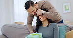 Couple, home and surprise gift with cover for anniversary celebration, smile or partner appreciation. Eyes closed, giving present and happy people on sofa for care, relationship connection and love