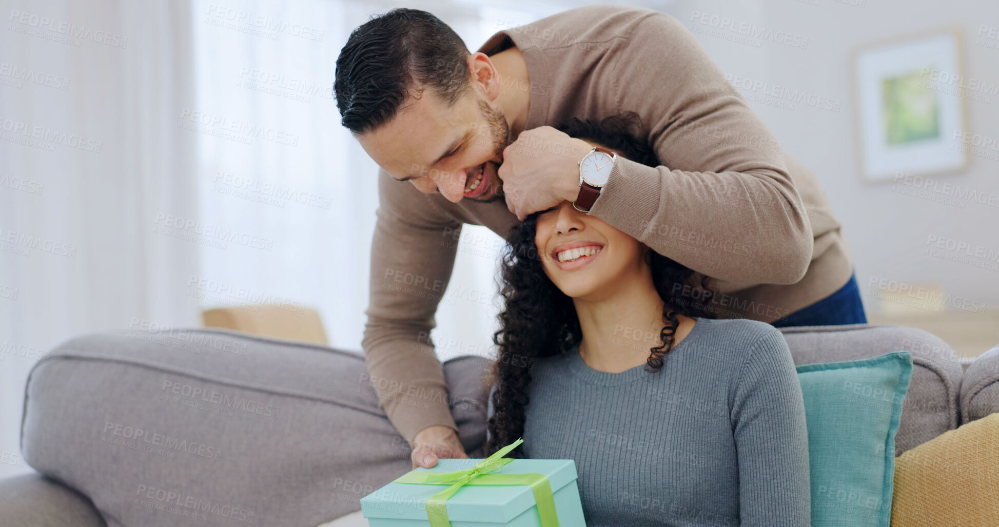 Buy stock photo Couple, home and surprise gift with cover for anniversary celebration, smile or partner appreciation. Eyes closed, giving present and happy people on sofa for care, relationship connection and love