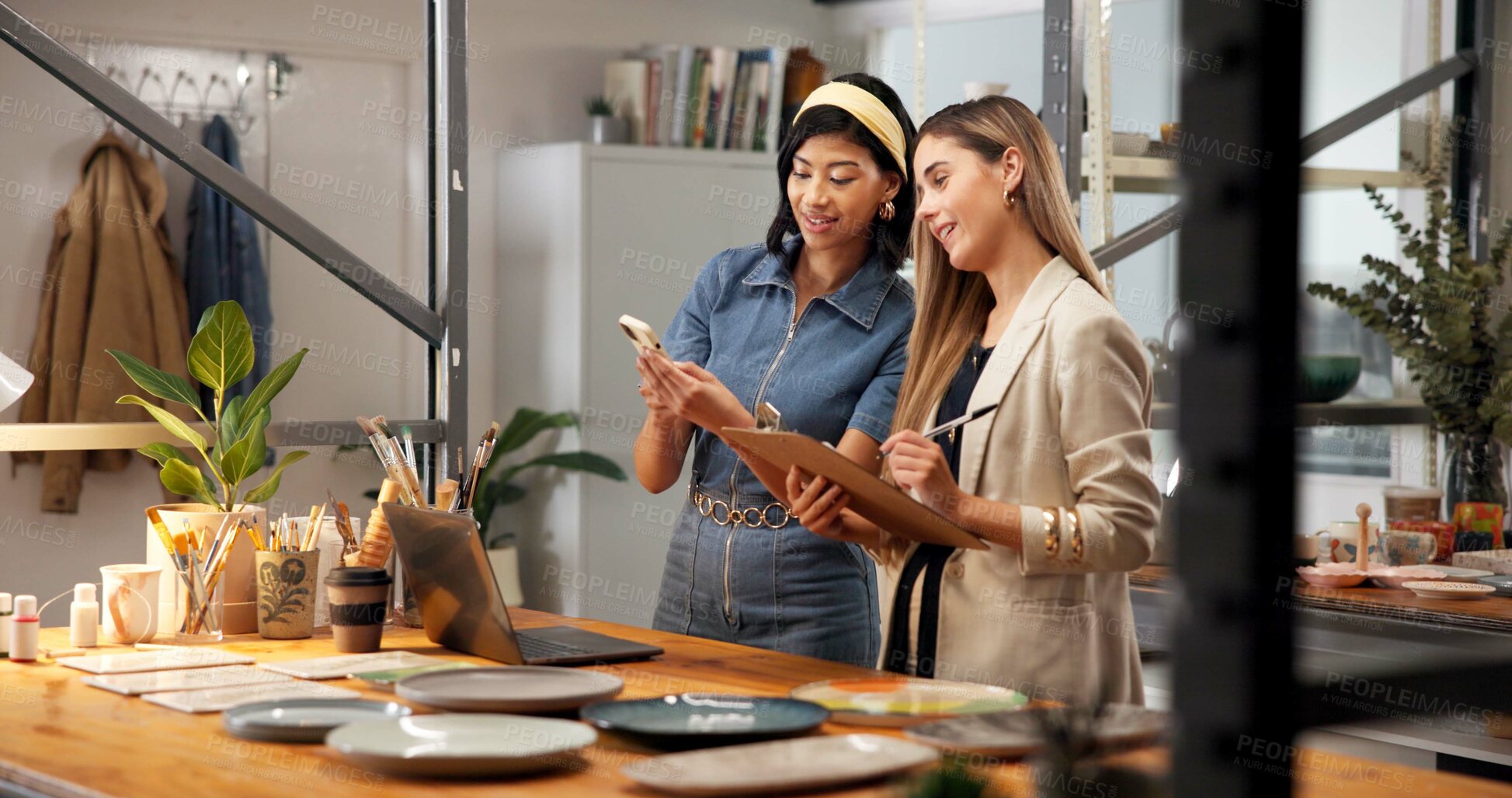 Buy stock photo Pottery, team and phone in art studio with clipboard, discussion or website for inventory management. Women, talk and tech in small business with checklist, design trends and plan for ceramics shop.