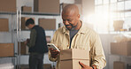 Ecommerce, man and phone in office with boxes, courier order or smile for positive review on website. Happy, mature person and package with tech, supply chain and mobile app with customer feedback.